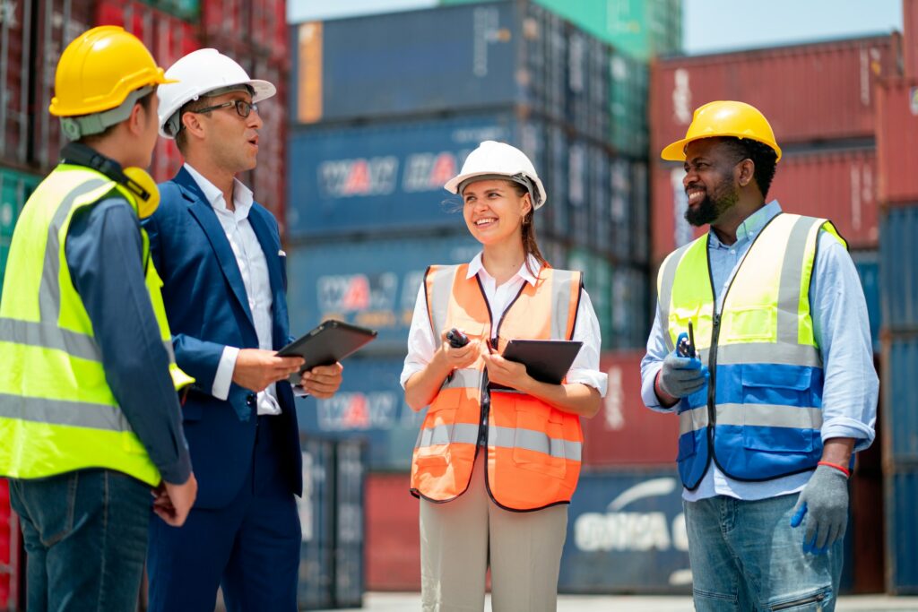 Group of multi ethnic cargo contianer workers stand and discuss together about the project