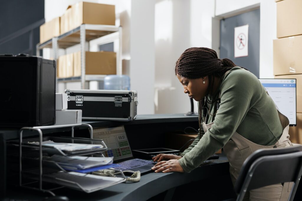 Storehouse manager analyzing goods logistics on laptop